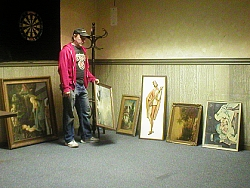 K.L. sets out pictures for the walls of the Balbino's set